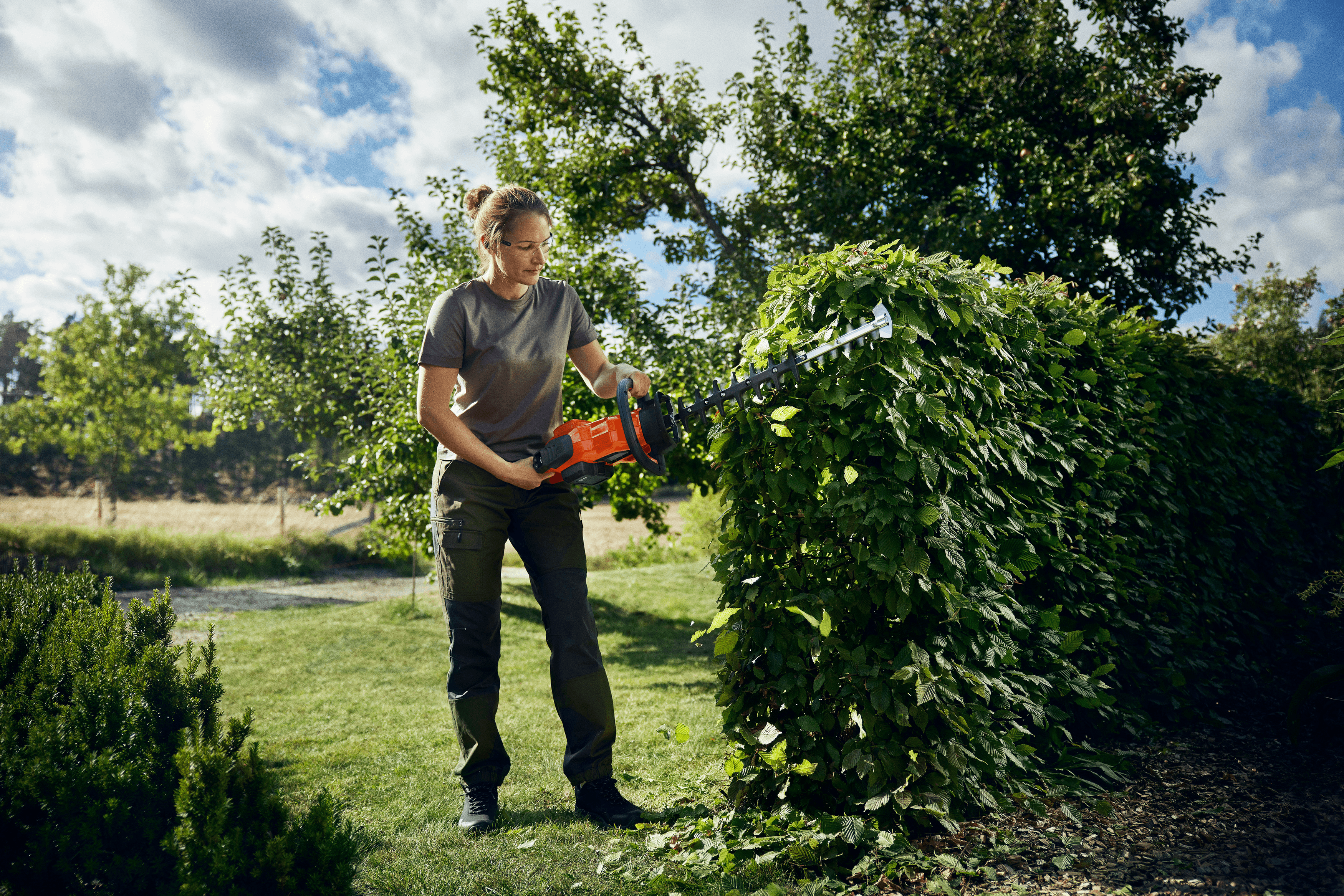 man holding chainsaw whilst cutting tree